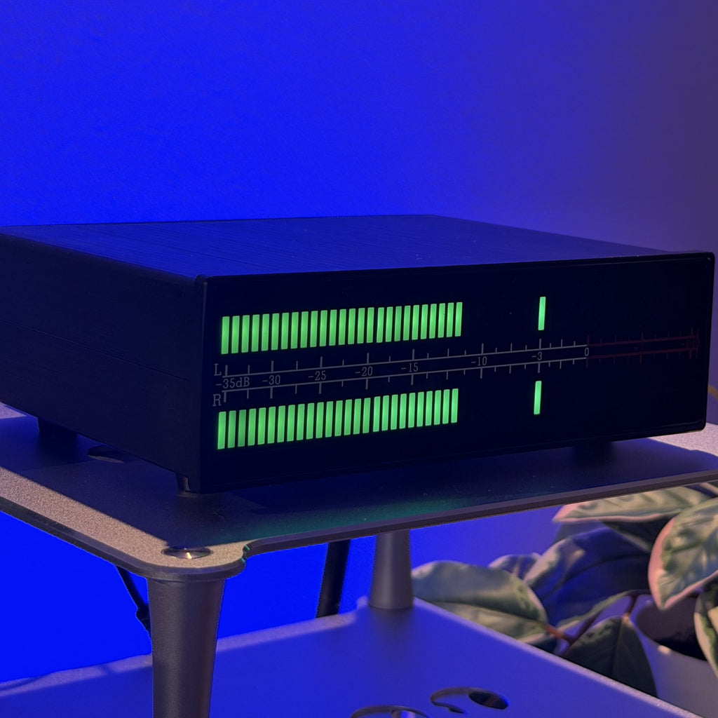 Douk Audio VU56 PRO encendido en un rack de escritorio, foto real del medidor VU LED